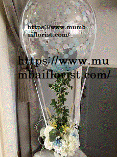 Transparent balloon with confetti and 20 white flowers arrangement and trailing leaves