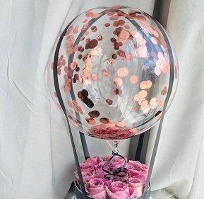 Transparent Balloon stuffed with confetti Tied with ribbons to a basket containing 20 pink roses